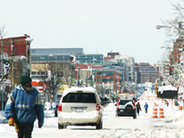 Photo of snow covered street with vehicles